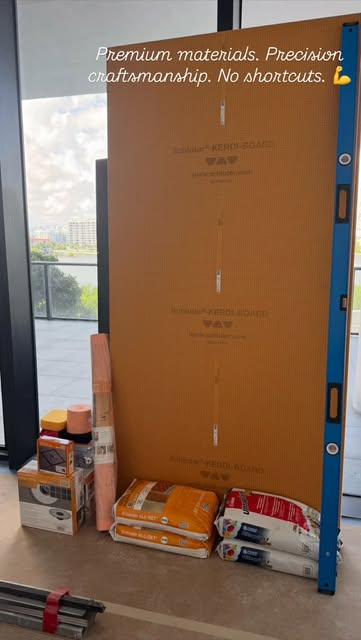 Boxes of tile and bags of setting materials staged on a high-rise balcony before a job