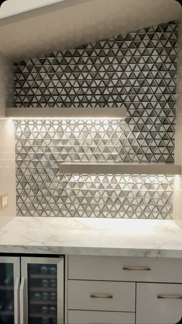 Triangle mosaic backsplash behind floating shelves