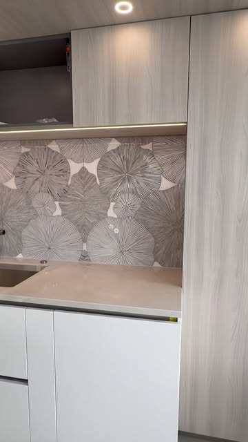 Large grey and white waterjet marble flowers covering a kitchen wall