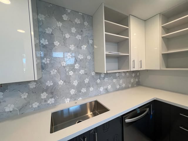 Floral marble mosaic backsplash around a corner sink